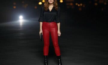 Skórzane spodnie w odcieniu czerwieni z obcisłym krojem, zestawione z bluzką z wycięciami i botkami na wieczór w rockowym stylu